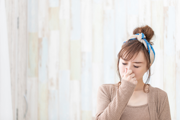鼻をつまむ女性の画像